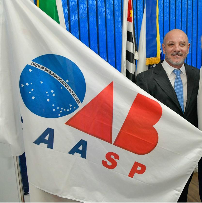 Dr. Fábio Campanile ao lado das bandeiras da OAB e AASP